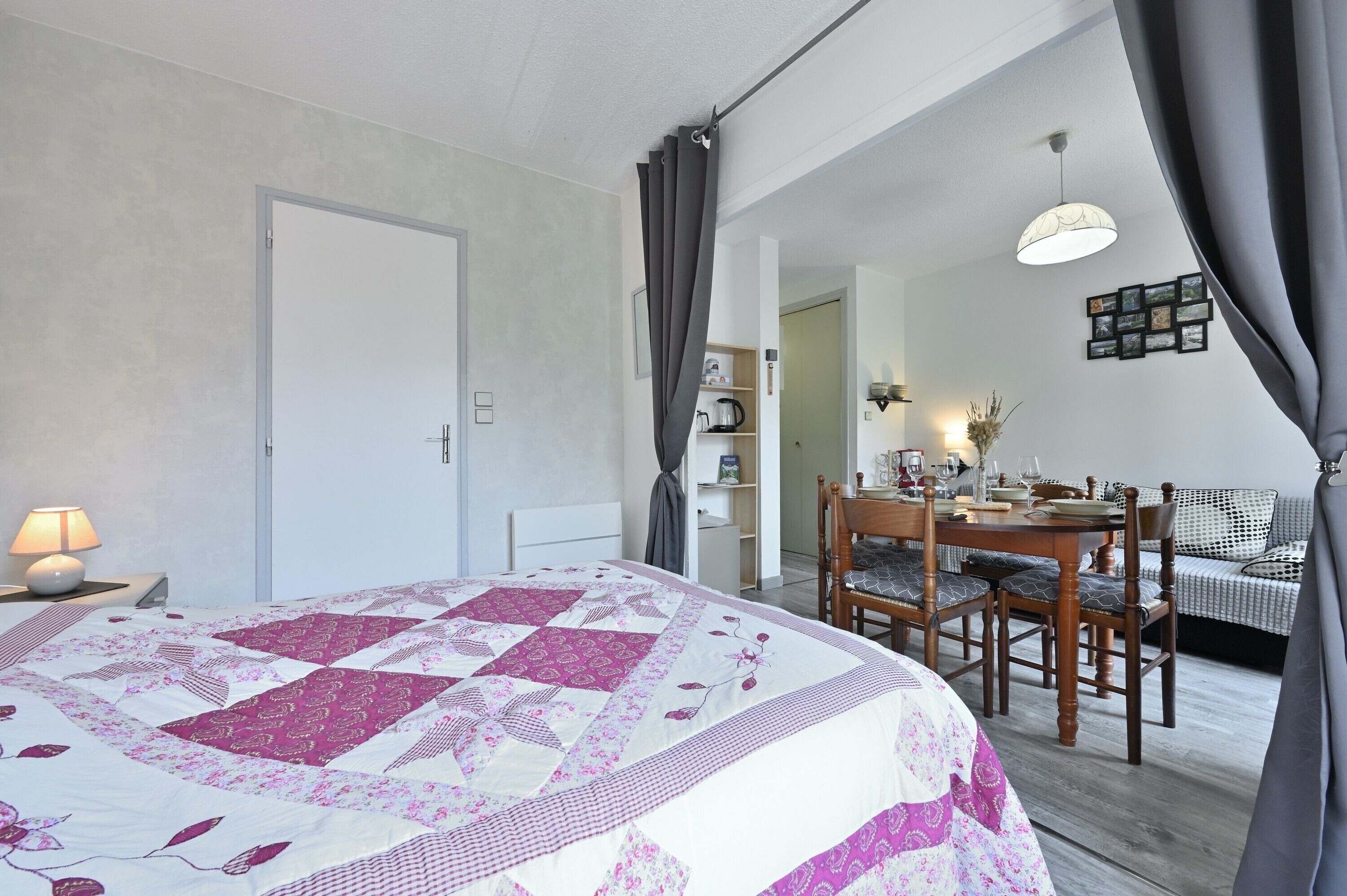 Un dormitorio con cama, escritorio, silla, mesa de comedor y sofá.