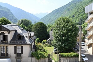 Un barrio residencial con casas, un árbol y montañas al fondo.