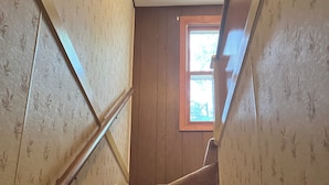 Una escalera empapelada con barandillas de madera y alfombra.