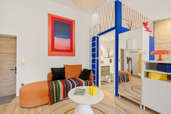 Un salon moderne avec un canapé, une table basse et un plaid rayé aux couleurs vives.