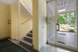 Un escalier menant à une porte donnant sur un espace extérieur aménagé.