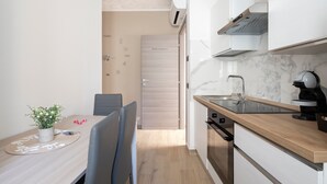 Cocina compacta con encimera de madera, horno integrado y grifo moderno.