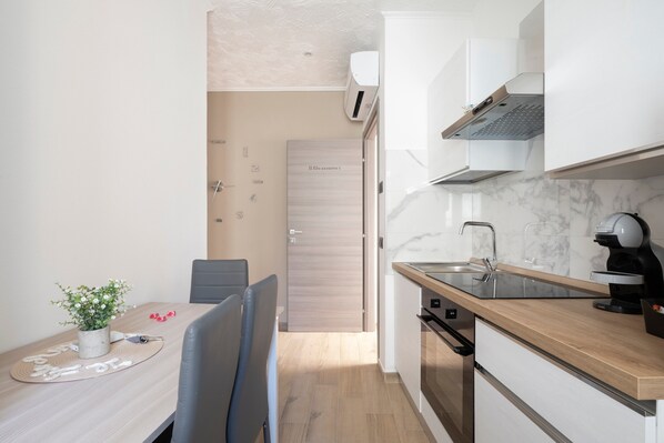 A compact kitchen with a wooden countertop, a built-in oven, and a modern faucet.