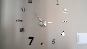 A wall clock with numbers and letters indicating time.