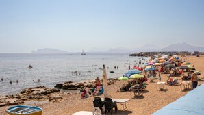 A beach with umbrellas, chairs, and tables. - Aurora Sul Mare Apartment with Wi-Fi and Air Conditioning (Palermo)