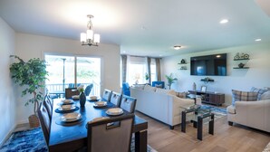 Amplia sala de estar con mesa de comedor, sofá y televisor.
