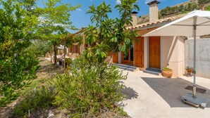 A modern house with a patio, a wooden door, and a potted plant. - Country House 'Lluna' with Mountain View, Shared Pool and Wi-Fi (Ibi)
