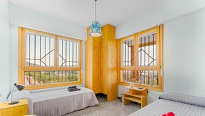 A room with two beds, a desk, a chair, and large windows with wooden frames. - Country House 'Sol' with Mountain View, Shared Pool and Wi-Fi (Ibi)