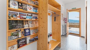 A room with wooden shelves filled with books, a wooden door with a sign reading 'SALIDA,' and a view of the sea through the door. - Country House 'Sol' with Mountain View, Shared Pool and Wi-Fi (Ibi)