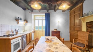 Una cocina con armarios de madera, una estufa y una mesa de comedor con sillas.