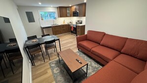 Un espace de vie compact comprenant un coin repas, un canapé et une cuisine.