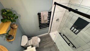 Une salle de bain moderne avec une douche à parois de verre, des toilettes et un lavabo.