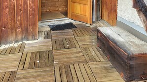 Una cabaña de madera con escalera de madera, una puerta y una terraza de madera.