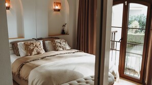 Una camera da letto con un letto, una ventola a soffitto e vista su uno spazio all'aperto tramite una porta in vetro.