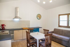 Eine Küche mit Herd, Spüle und einer Uhr an der Wand.
