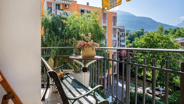A balcony with a table, a bench, and a potted plant. - Apartment 'Re 1' with Balcony, Wi-Fi and Air Conditioning (Trento)