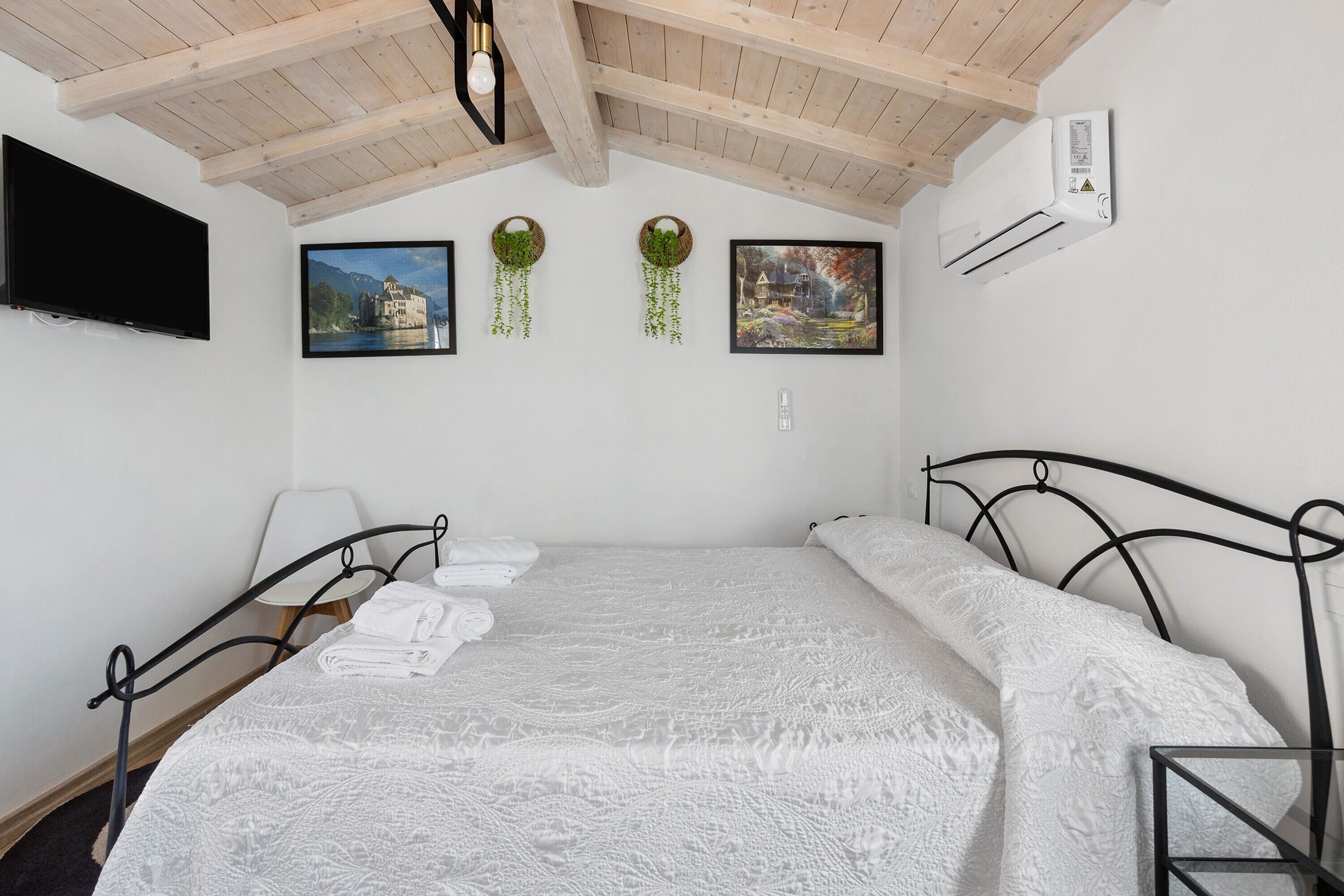 Una camera da letto con un letto, una televisione e condizionatore d'aria a muro.