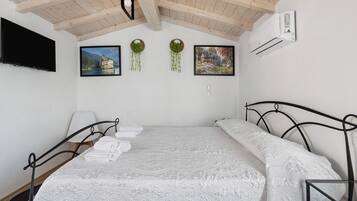 Una camera da letto con un letto, una televisione e condizionatore d'aria a muro.
