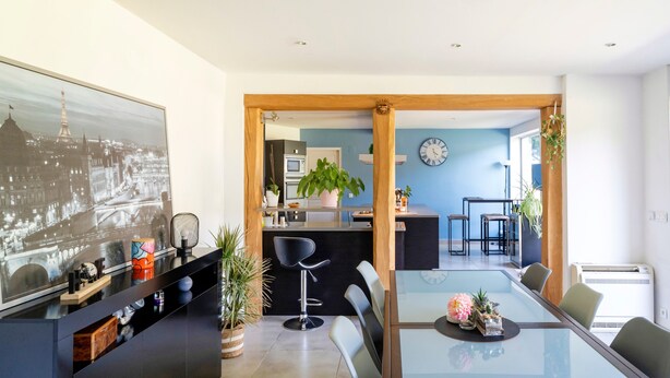 A modern kitchen with a central island, a dining area with a glass table, and a living space with a large framed picture. - Chambre d’hôtes Chêne with Air Conditioning – Serenity, Nature and Well-being in Gascony (Mauléon-d'Armagnac)