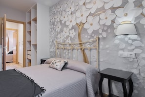 A bedroom with a bed, a nightstand, a wall-mounted lamp, and a wardrobe. - Holiday Home 'Lago De Sanabria' with Mountain View, Private Garden and Balcony (Coso)