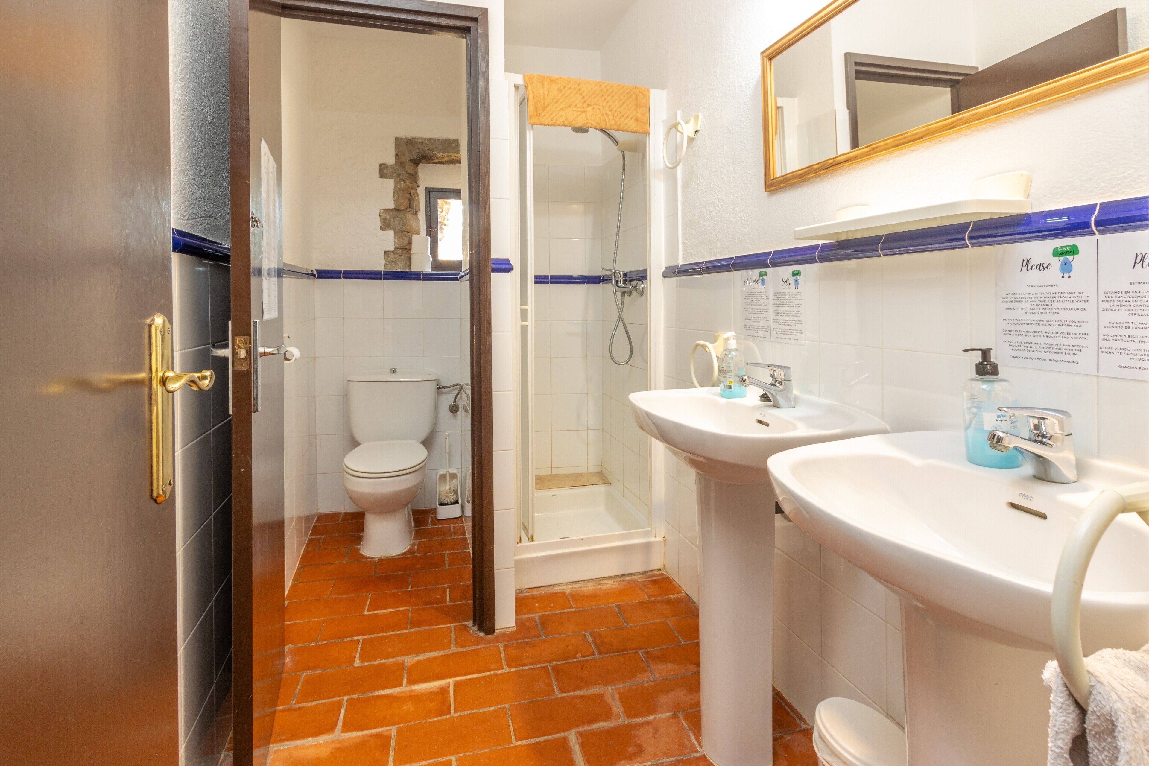 A bathroom with a shower, toilet, and two sinks.