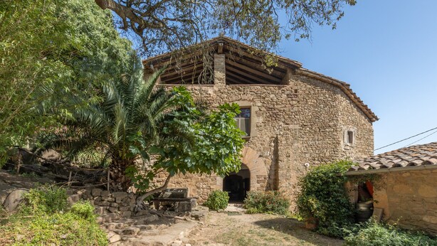 Un bâtiment en pierre, à l’aspect rustique, avec une porte en bois et une petite fenêtre.