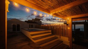 A wooden deck with a hot tub, string lights, and a view of the sunset. - Holiday Home 'Xuixo In Tenerife South' with Sea View, Wi-Fi and Air Conditioning (Guía de Isora)