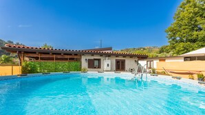 A swimming pool with a house in the background.
