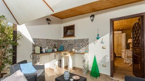 A cozy living area with a sofa, a small table, and a kitchen area with a tiled backsplash.