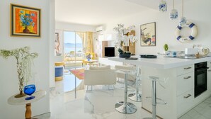 A modern kitchen with a large island, bar stools, and a view of the outdoors.