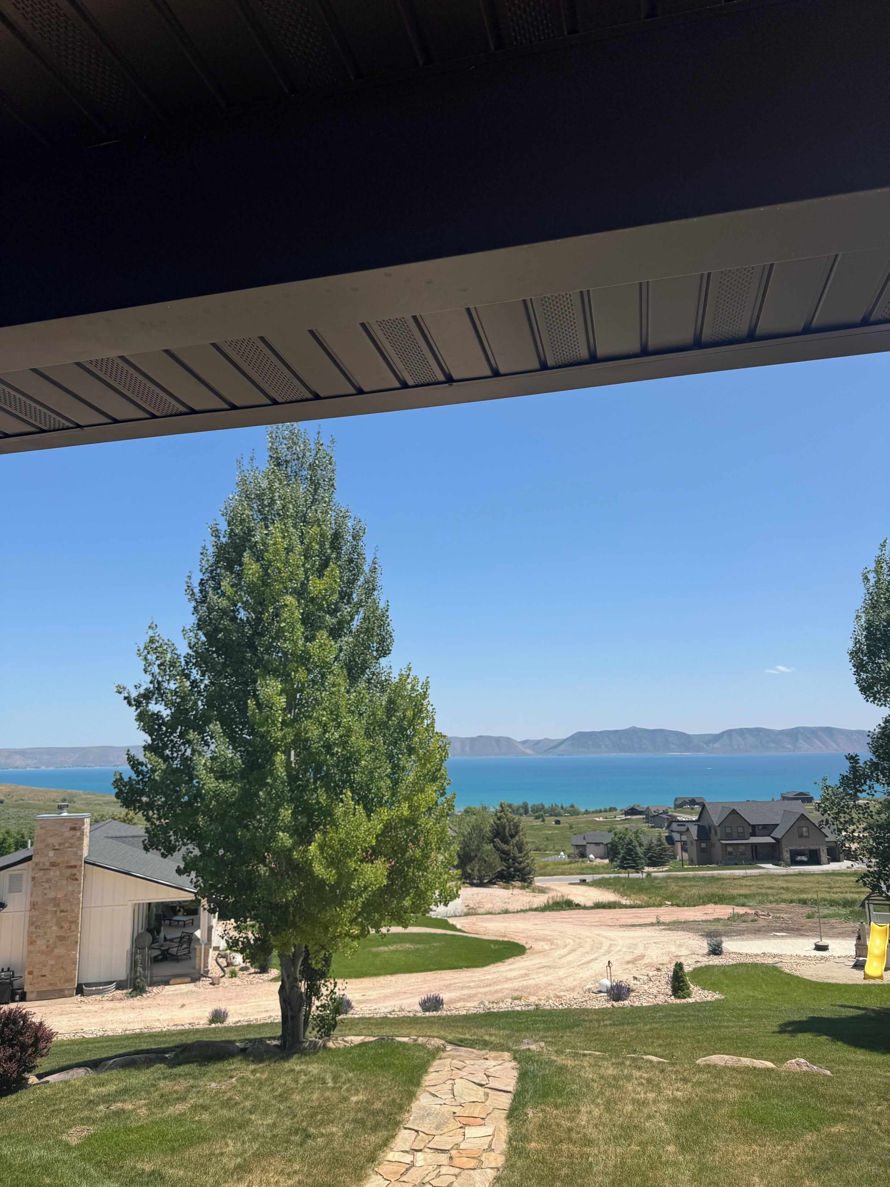 A residential area with a clear view of a lake and mountains in the distance.