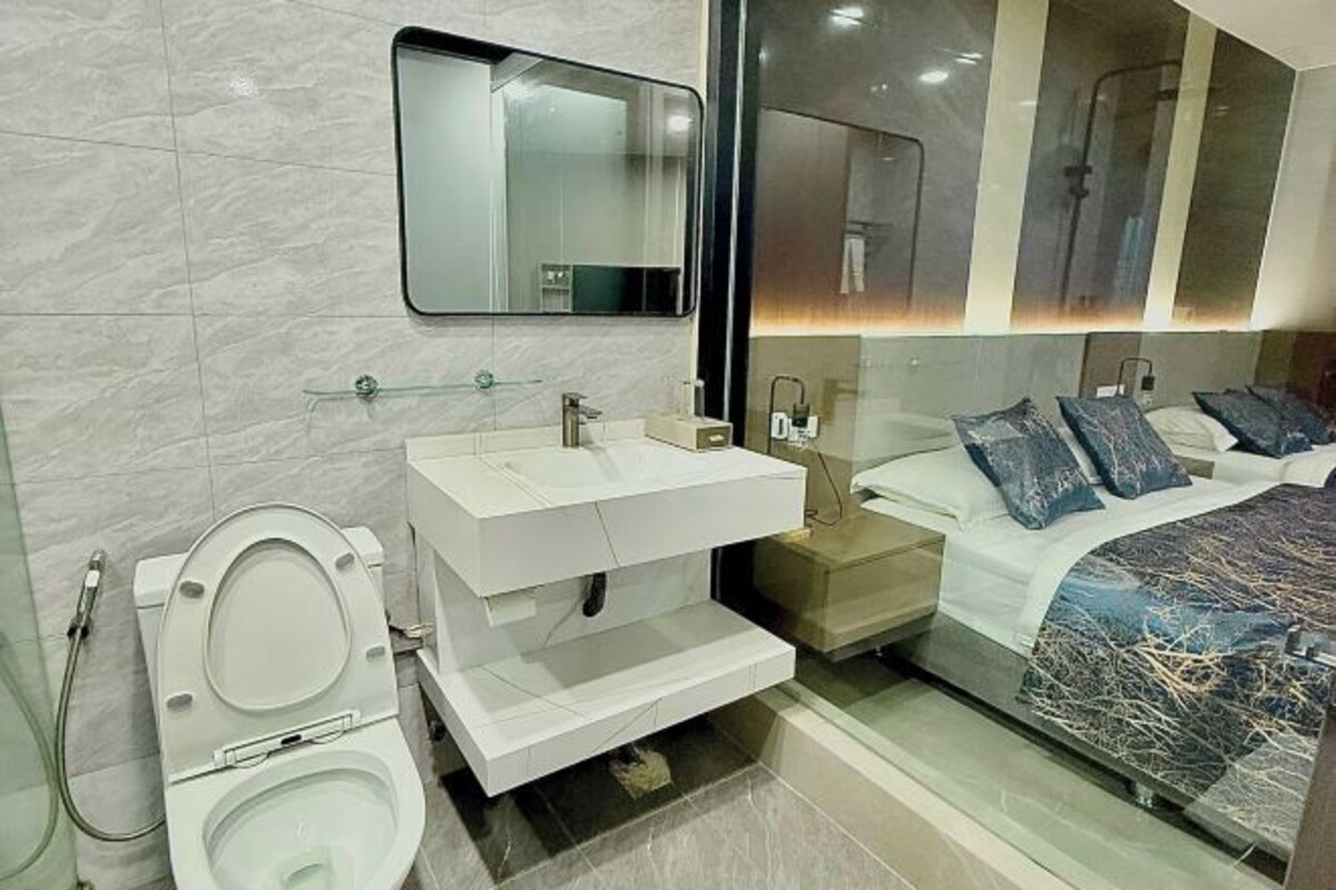 A modern bathroom with a toilet, sink, and mirror.