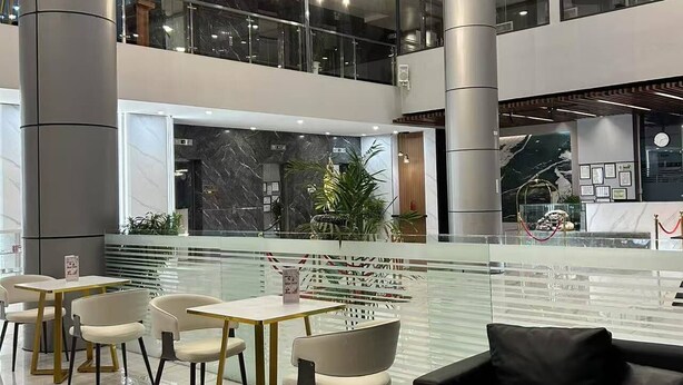 A modern indoor space with a central water feature, seating areas, and a mezzanine level. - Skyport Hotel (Pasay)