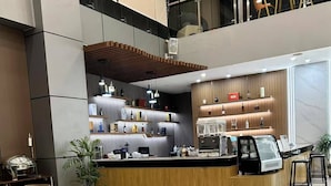 A modern cafe with wooden furniture and a counter displaying beverages. - Skyport Hotel (Pasay)