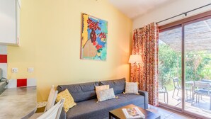 Una sala de estar con un sofá, una mesa de centro y un cuadro en la pared.