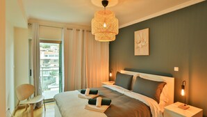 A hotel room with a large bed, a chair, a bedside table with a lamp, and a view of the outside. - The Panoramic View in Machico (Machico)
