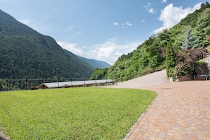 A paved pathway leading to a building with a view of a mountainous landscape.