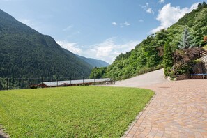 A paved pathway leading to a building with a view of a mountainous landscape.