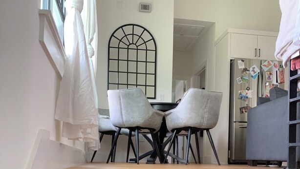 A staircase leading to a dining area with a table and chairs.