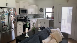 A modern kitchen with white cabinets, stainless steel appliances, and a black countertop.