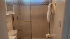 Ein Badezimmer mit Toilette, Waschbecken und Duschbereich.