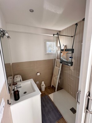 Un baño con bañera, ducha, toallero y ventana.