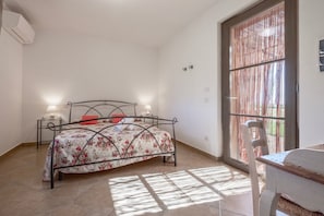 Une chambre à coucher avec un lit, des lampes de chevet, une chaise et une fenêtre donnant sur un beau paysage.