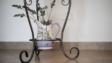 A metal stand with a white pitcher and a purple bowl containing lavender flowers.