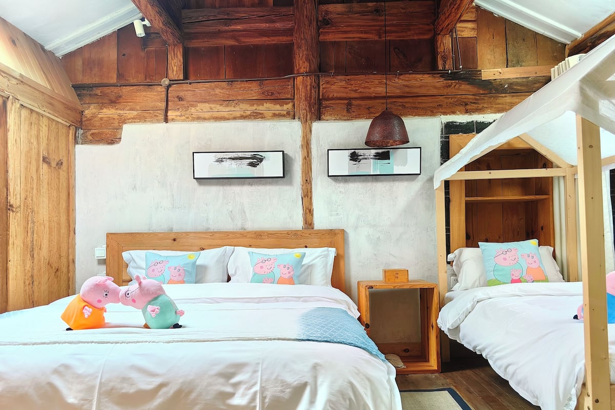 Ein gemütliches Schlafzimmer mit zwei Betten, Holzbalken und einer rustikalen Decke.