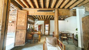 Interior rústico de madera con comedor, sofá y una mesa con cesta y tazas.