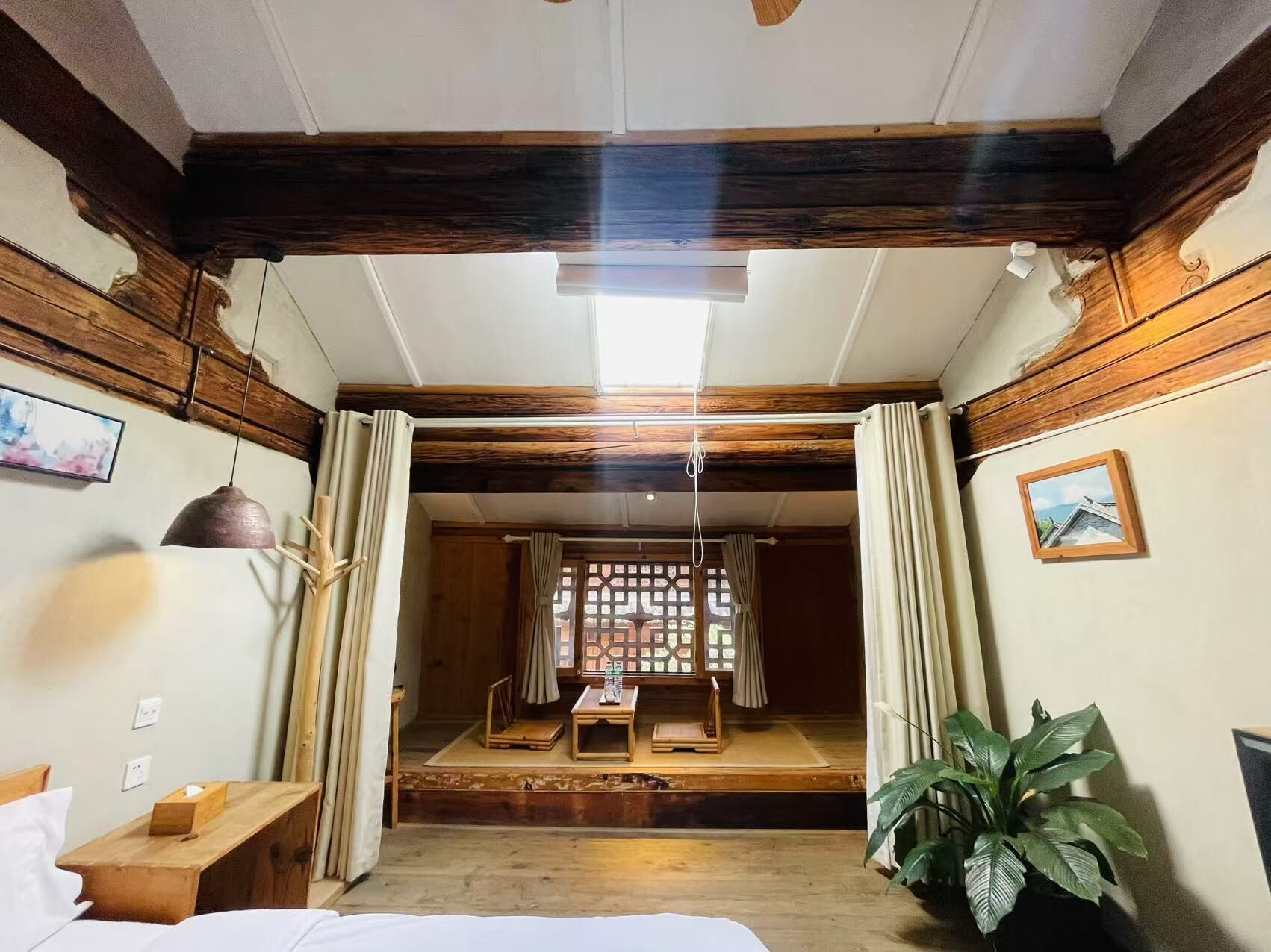 Una habitación tradicional japonesa con suelo de tatami, un celosía de papel shoji y una plataforma de madera baja.