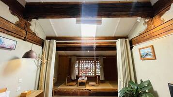 Una habitación tradicional japonesa con suelo de tatami, un celosía de papel shoji y una plataforma de madera baja.