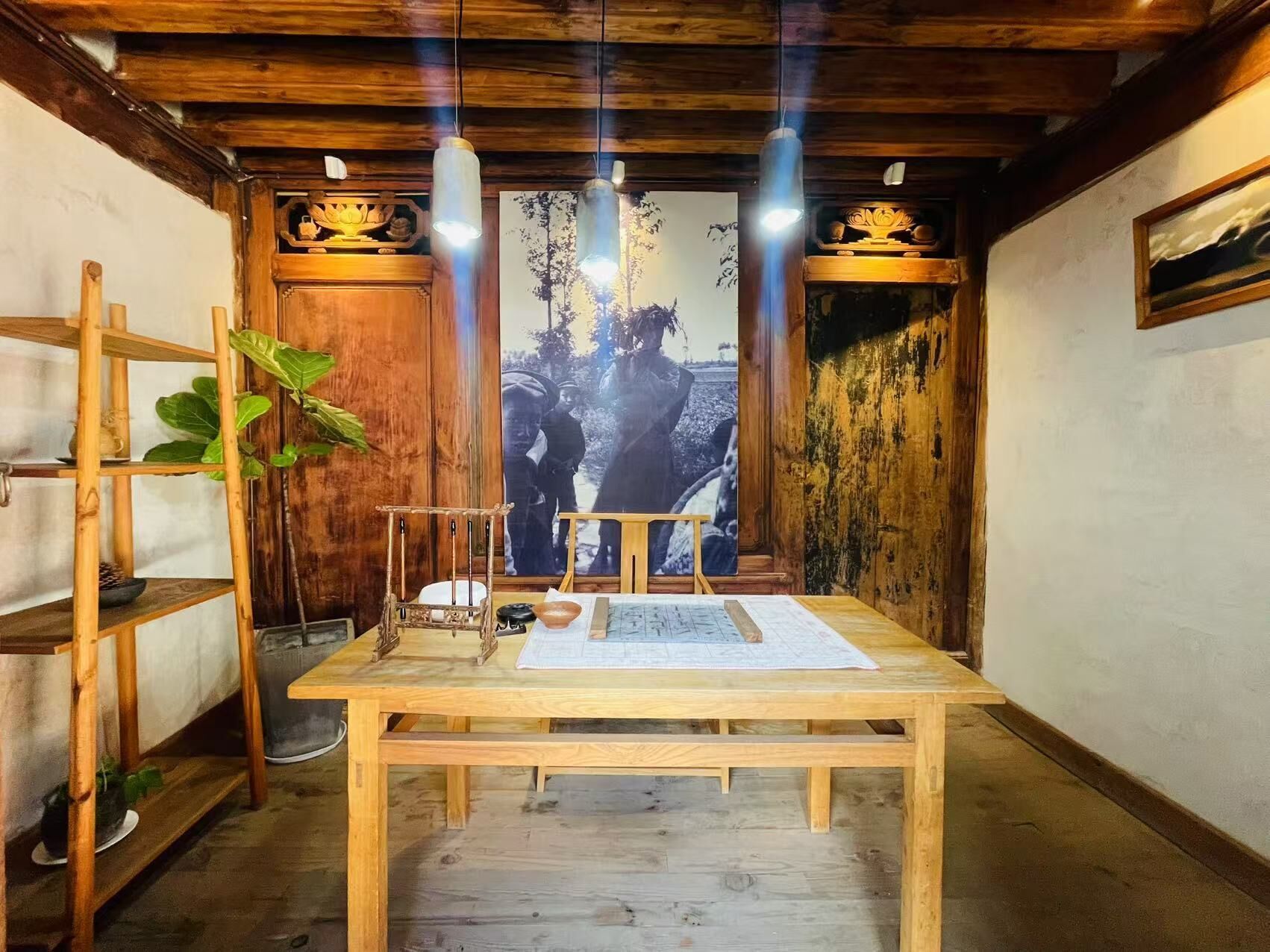 Interior em madeira com uma mesa, prateleiras e luminárias pendentes.