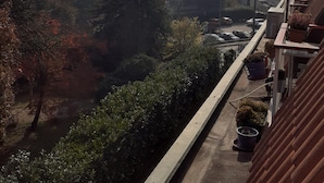 Een woonwijk met een heldere lucht, bomen en gebouwen op de achtergrond.